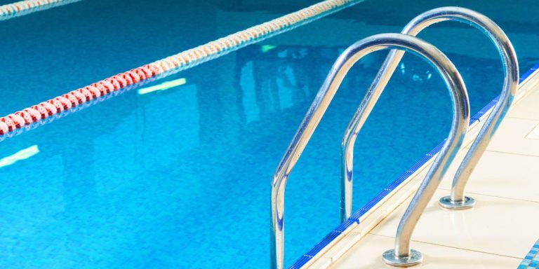 Kids playing in a residential pool with safety measures in place.